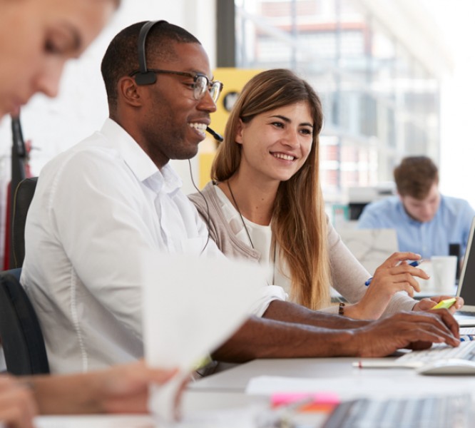 Two staff members sat at a computer